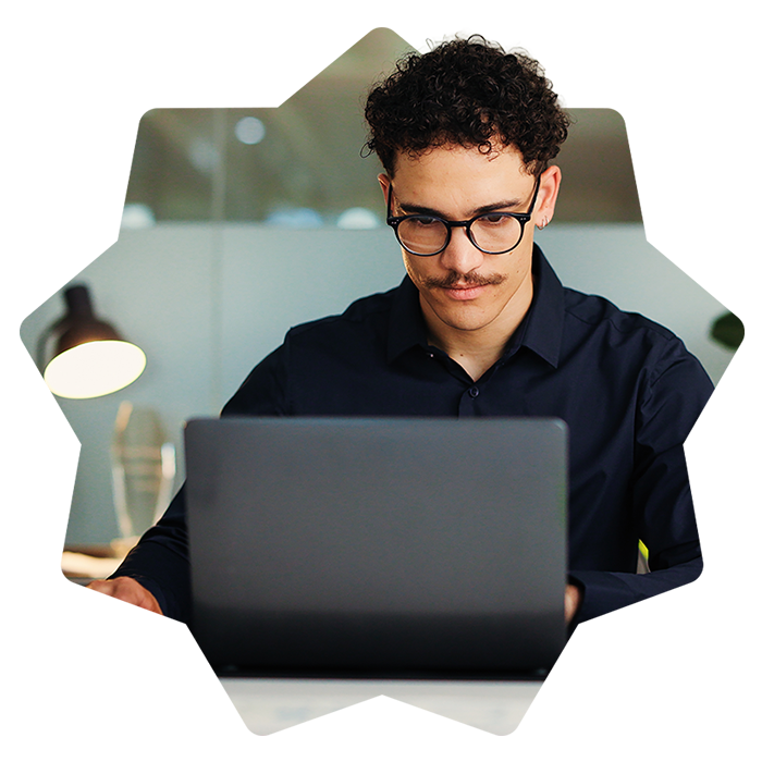 Jeune homme concentré sur son ordinateur portable dans un bureau moderne