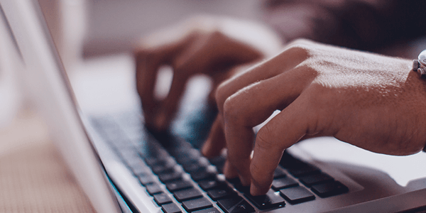 Close-up of typing on a laptop computer.