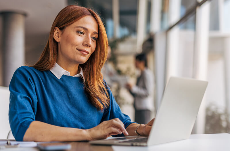 Femme d'affaires utilisant un ordinateur portable avec Gemini Enterprise dans un bureau