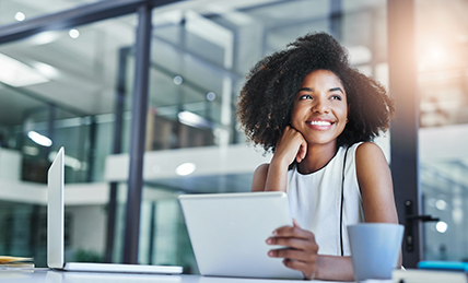 Woman smiling while working on a tablet