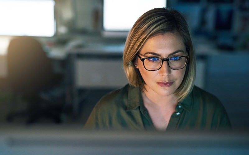 Close up of woman in glasses working on a laptop