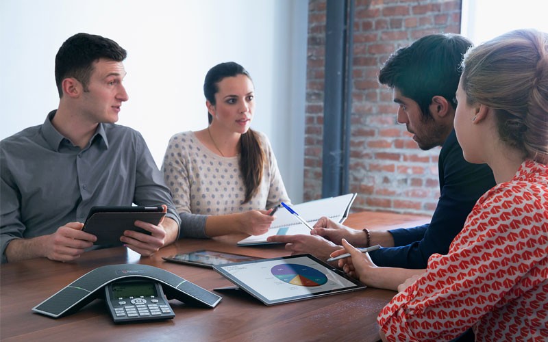 Group of people using Poly phone