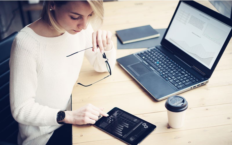 Woman using laptop and tablet device management software