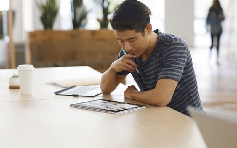 Young man working on 2-in-1- HP notebook device