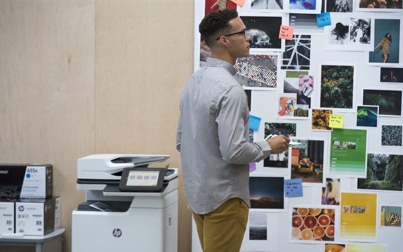 Young business man looking at all of printed papers