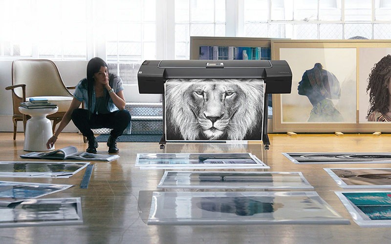Woman reviewing prints from a DesignJet printer
