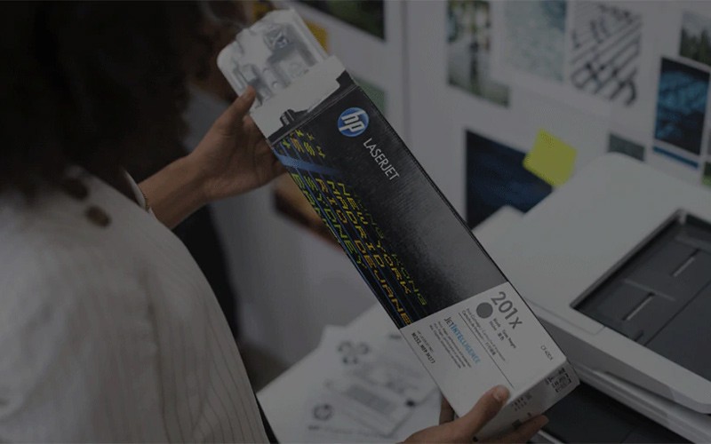 Woman holding a genuine HP toner cartridge
