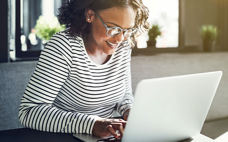 Woman smiling while using laptop