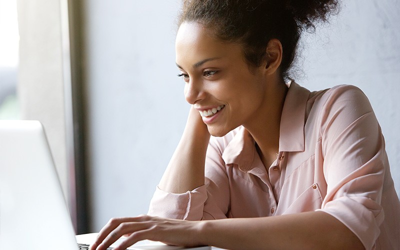Woman smiling while using laptop